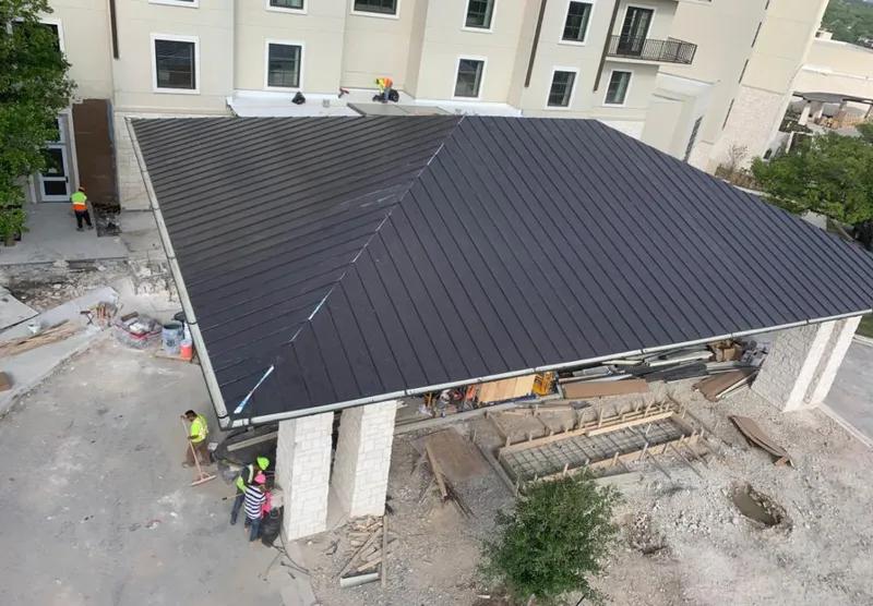 Metal roofing installation team working on a commercial building in Plainfield